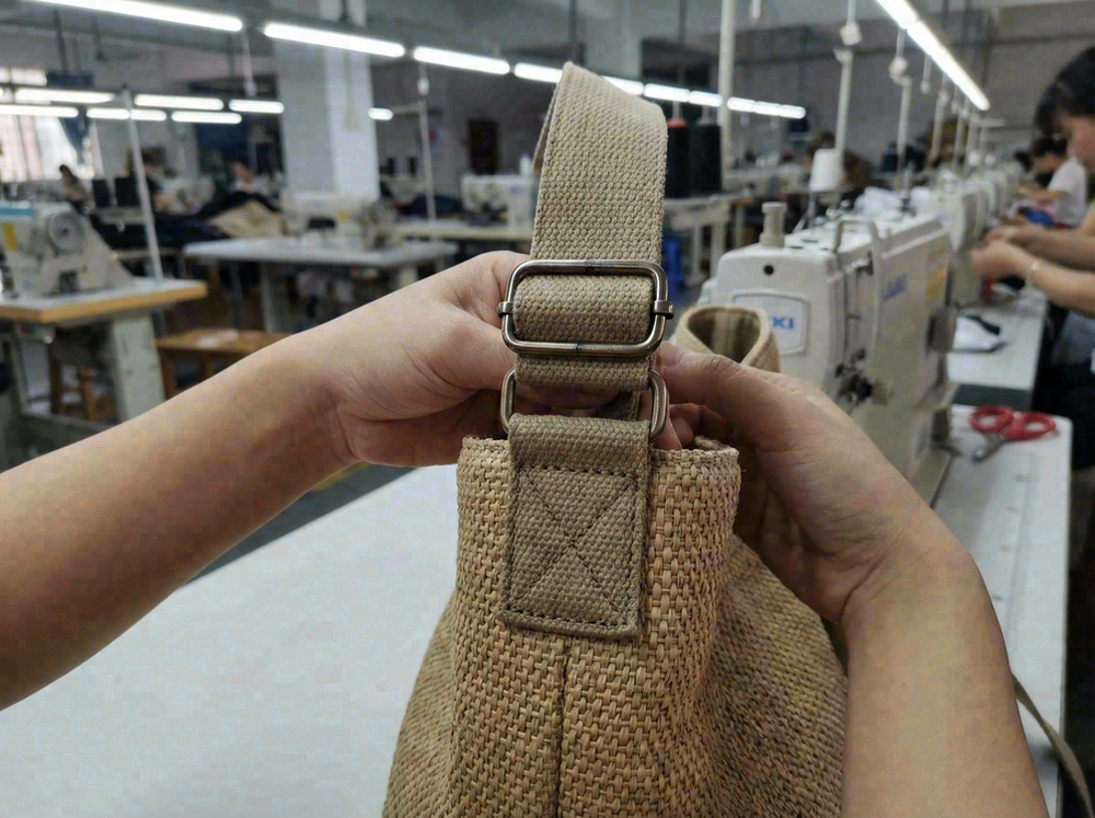Adjustable strap and hardware on beach bag showing reinforcement at stress points